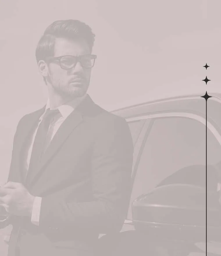 Homem de terno ao lado de um carro, ao telefone